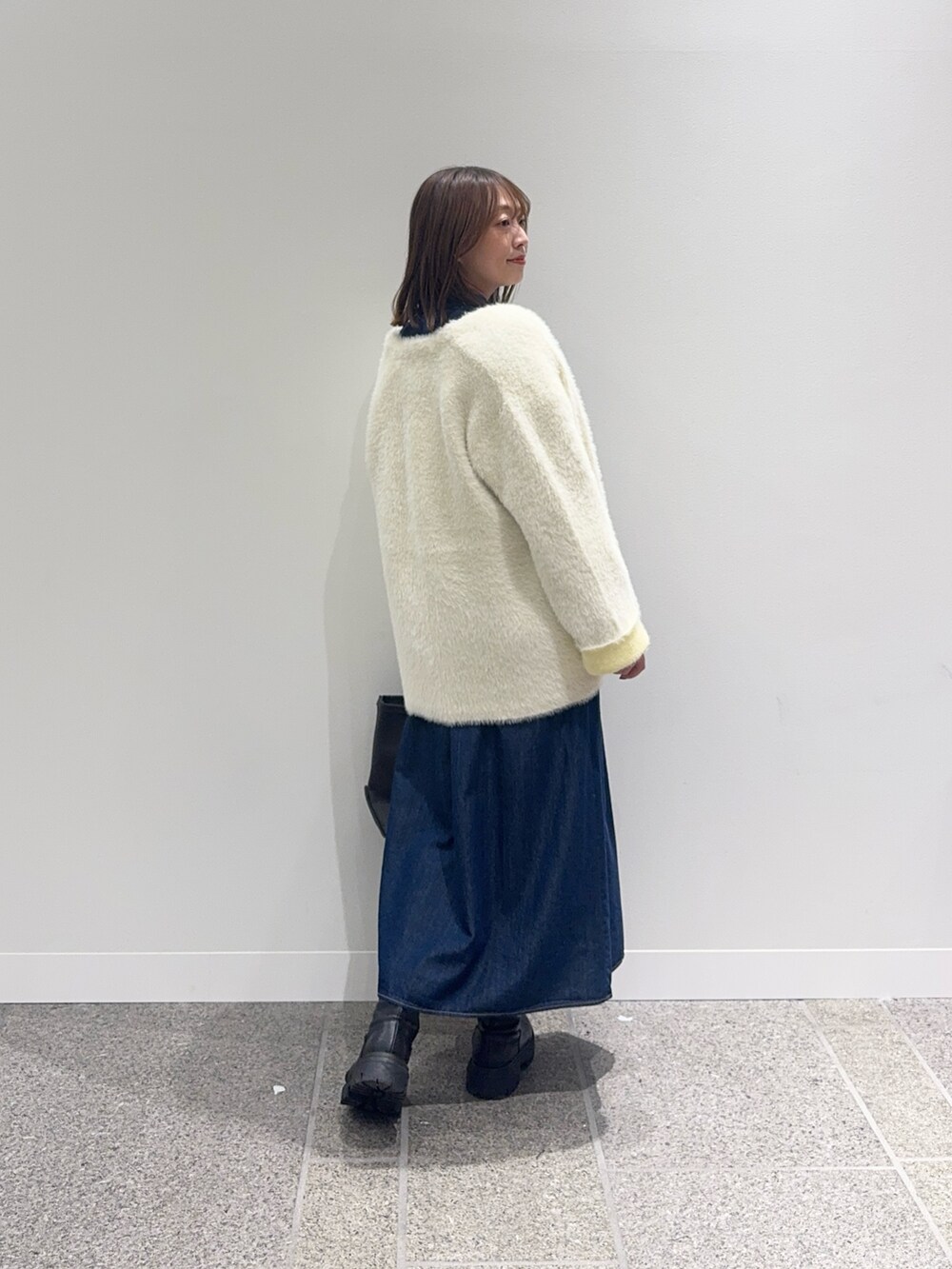ブルー系のワンピース、ホワイト系のカーディガン/ボレロ、グレー系のトートバッグを着用したレディースの秋コーディネートの4枚目の写真