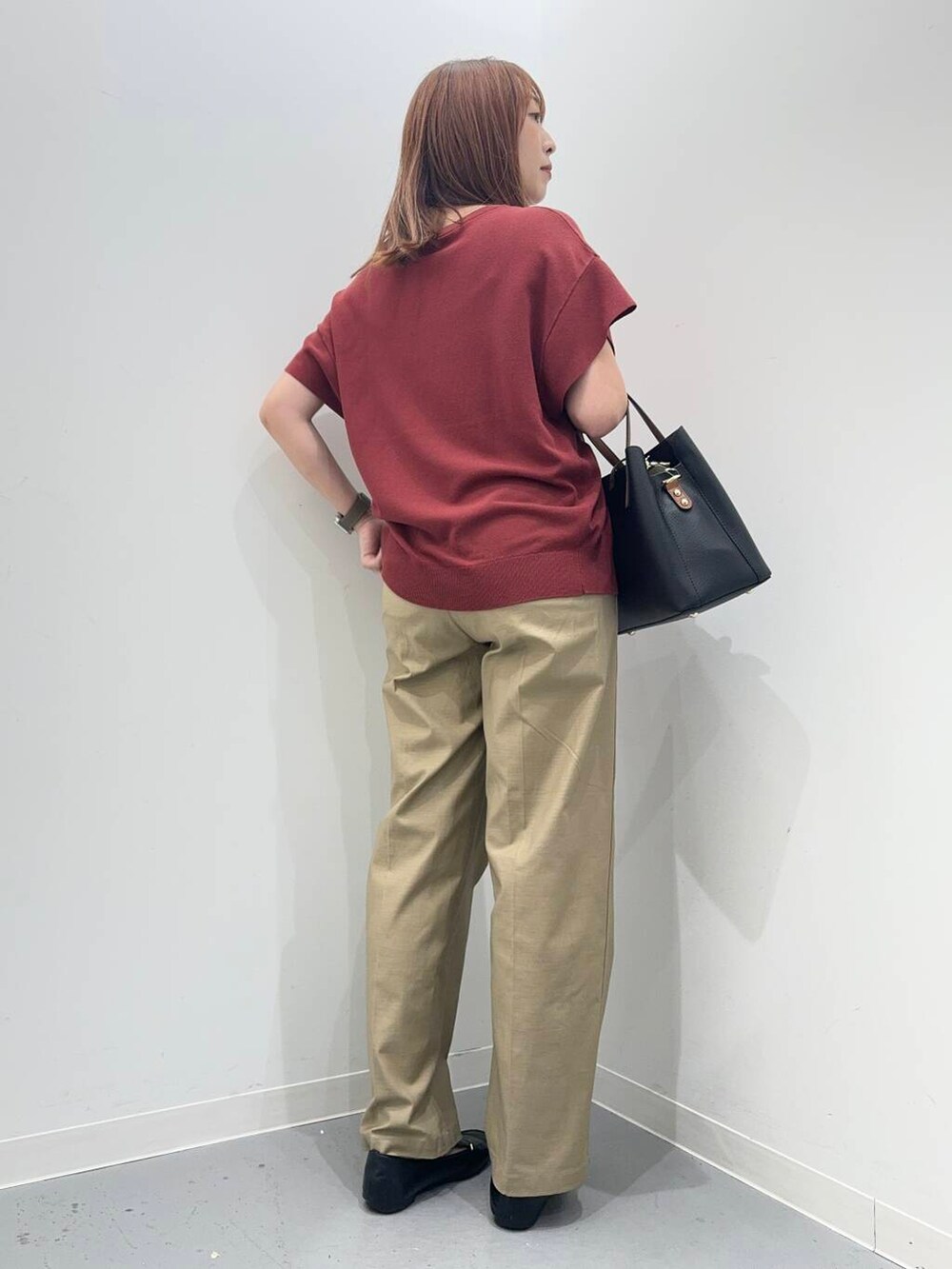 ブラック系のローファー、ブラック系のトートバッグ、レッド系のニット/セーターを着用したレディースの夏コーディネートの3枚目の写真