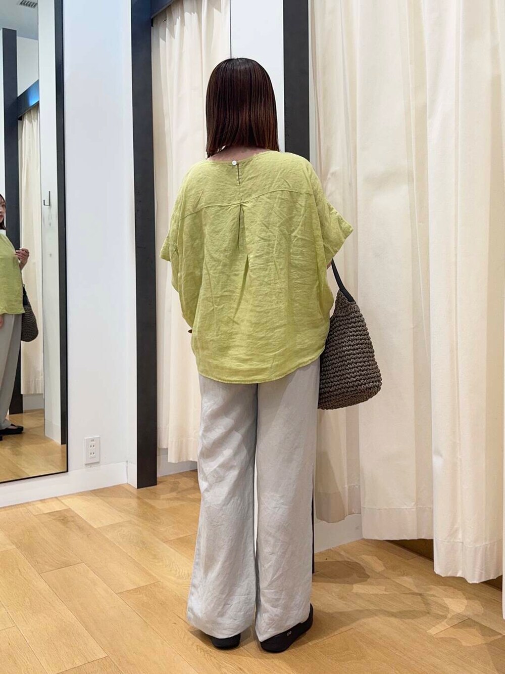 グレー系のトートバッグ、ブラック系のサンダル、イエロー系のシャツ/ブラウスを着用したレディースの夏コーディネートの4枚目の写真