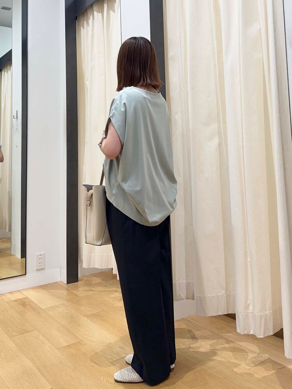 ホワイト系のトートバッグ、グリーン系のTシャツ/カットソー、ホワイト系のバレエシューズを着用したレディースの夏コーディネートの3枚目の写真