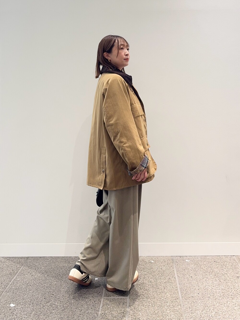 ベージュ系のその他アウター、ブラック系のショルダーバッグ、ベージュ系のスニーカーを着用したレディースの秋コーディネートの4枚目の写真