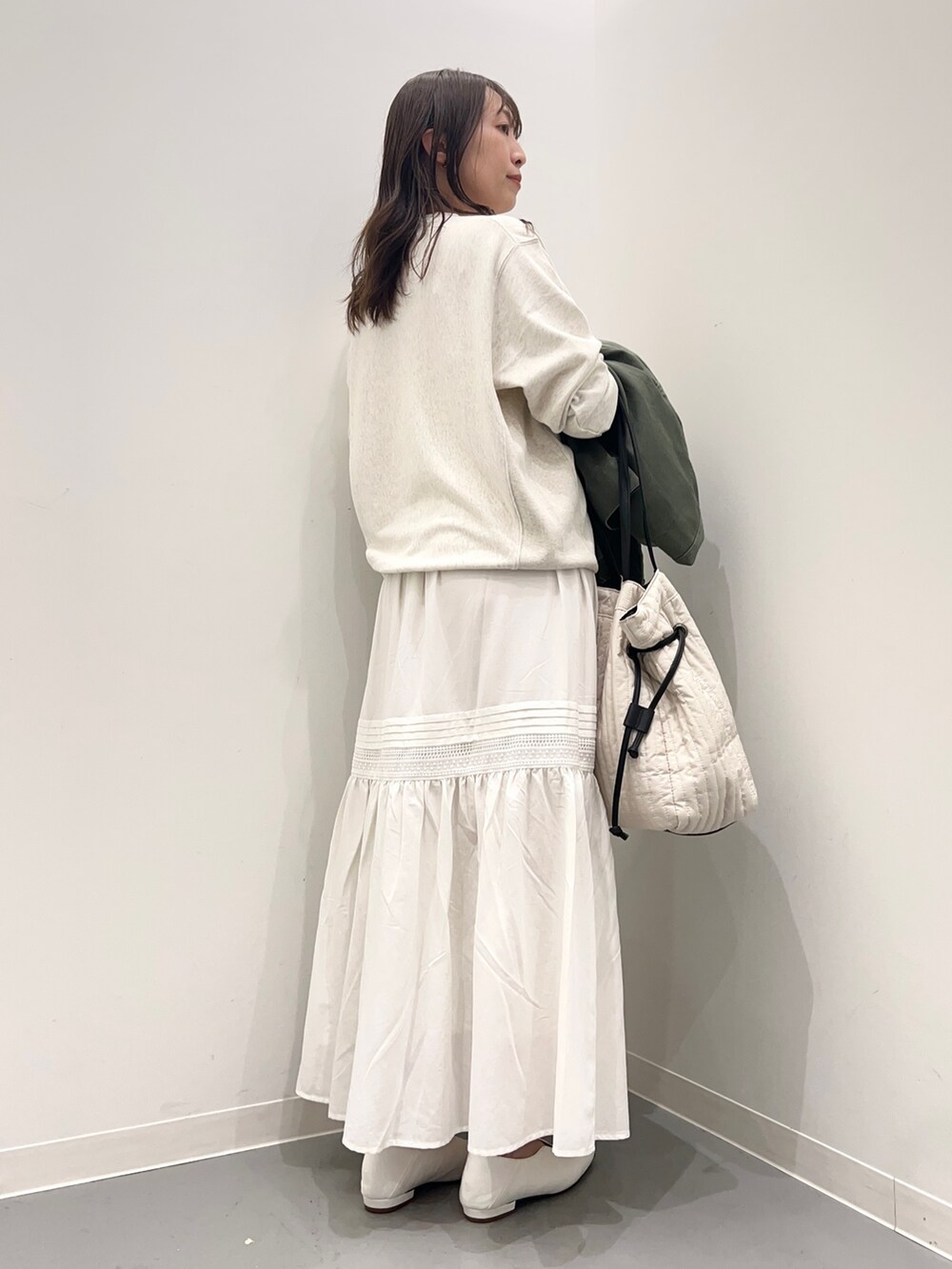 ベージュ系のスウェット、グリーン系のジャケット/アウター、ホワイト系のスカートを着用したレディースの夏コーディネートの7枚目の写真
