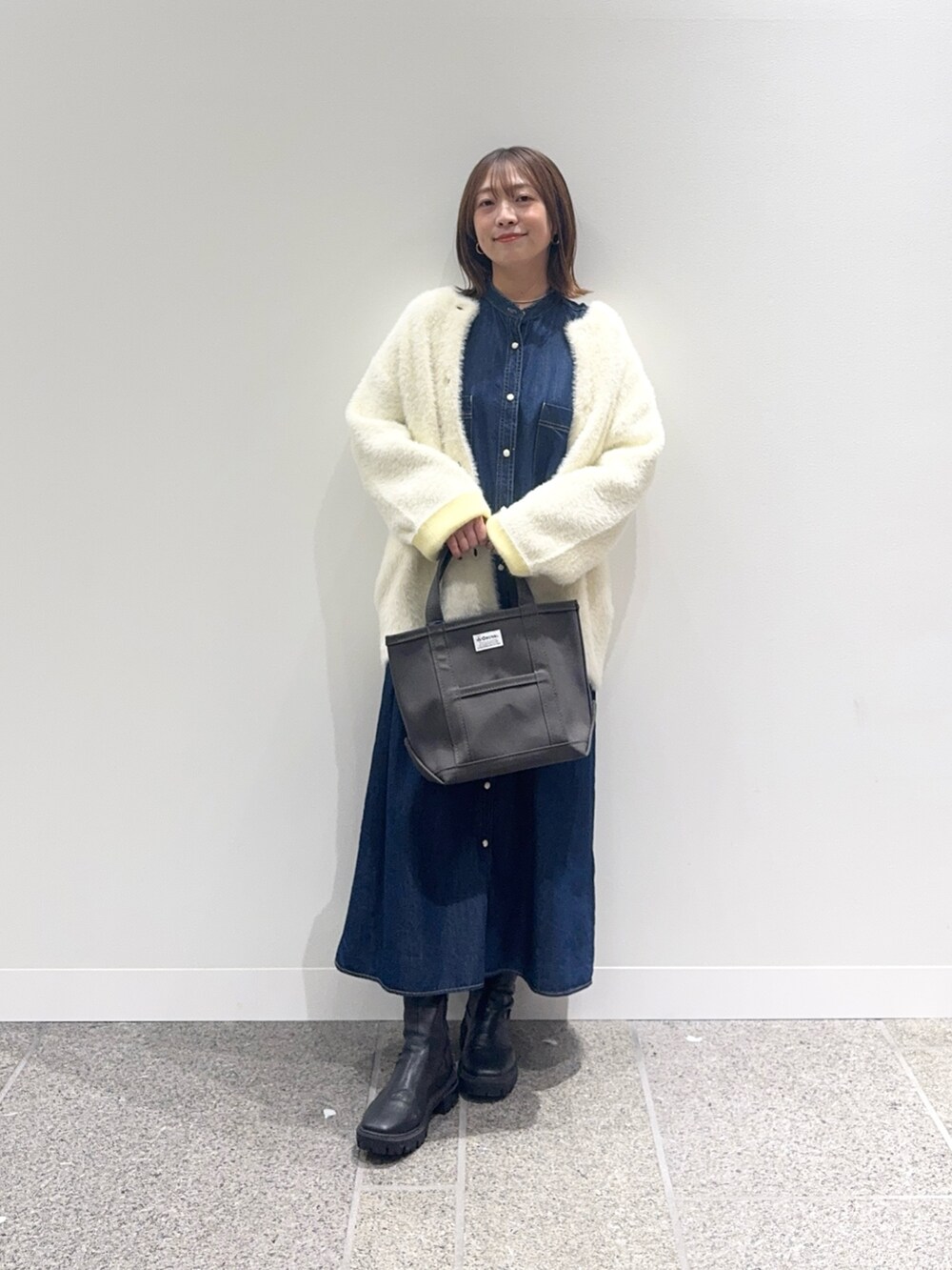 ブルー系のワンピース、ホワイト系のカーディガン/ボレロ、グレー系のトートバッグを着用したレディースの秋コーディネートの2枚目の写真