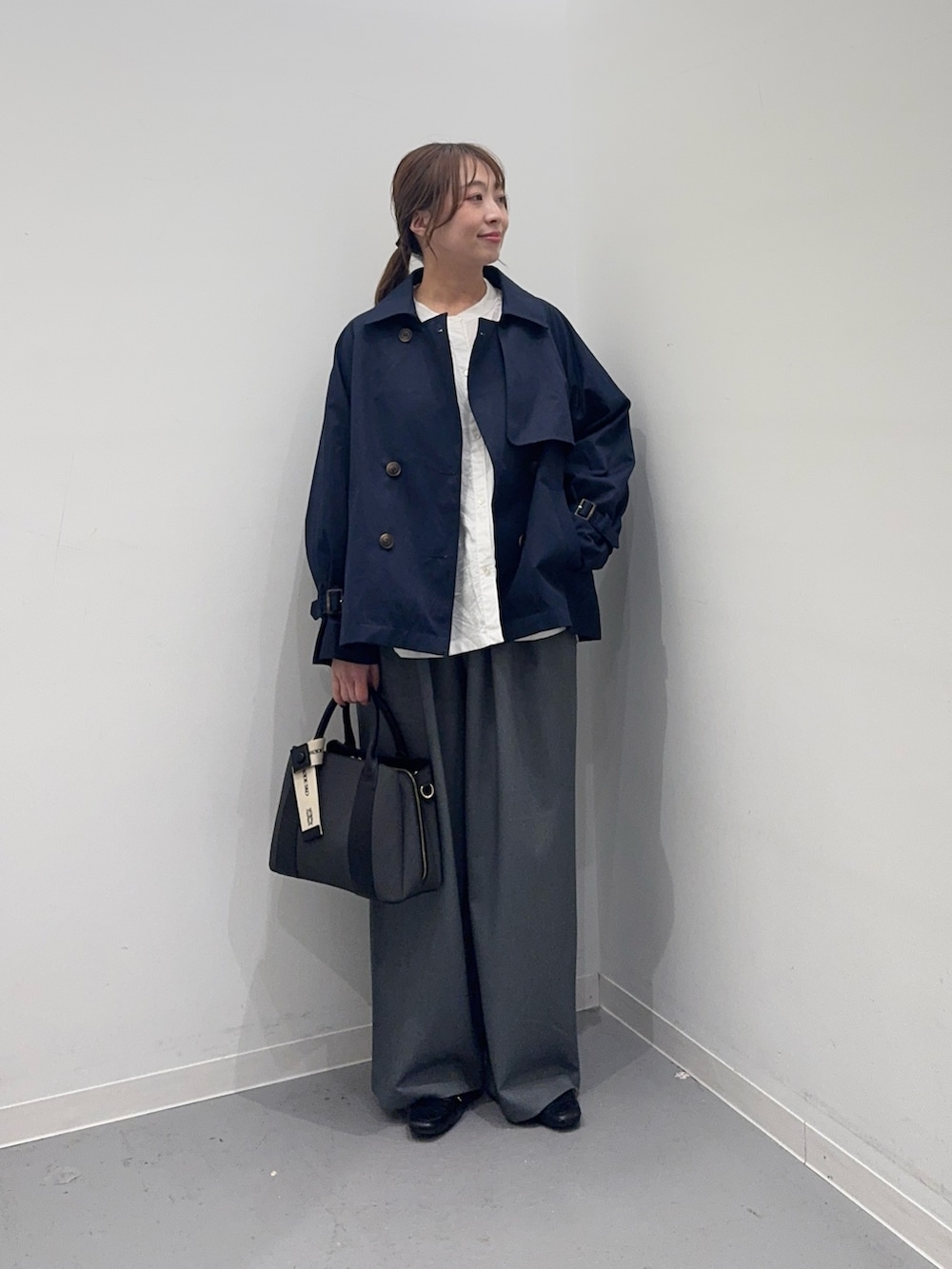 ブルー系のトレンチコート、ホワイト系のシャツ/ブラウス、グレー系のその他パンツを着用したレディースの春コーディネートの2枚目の写真