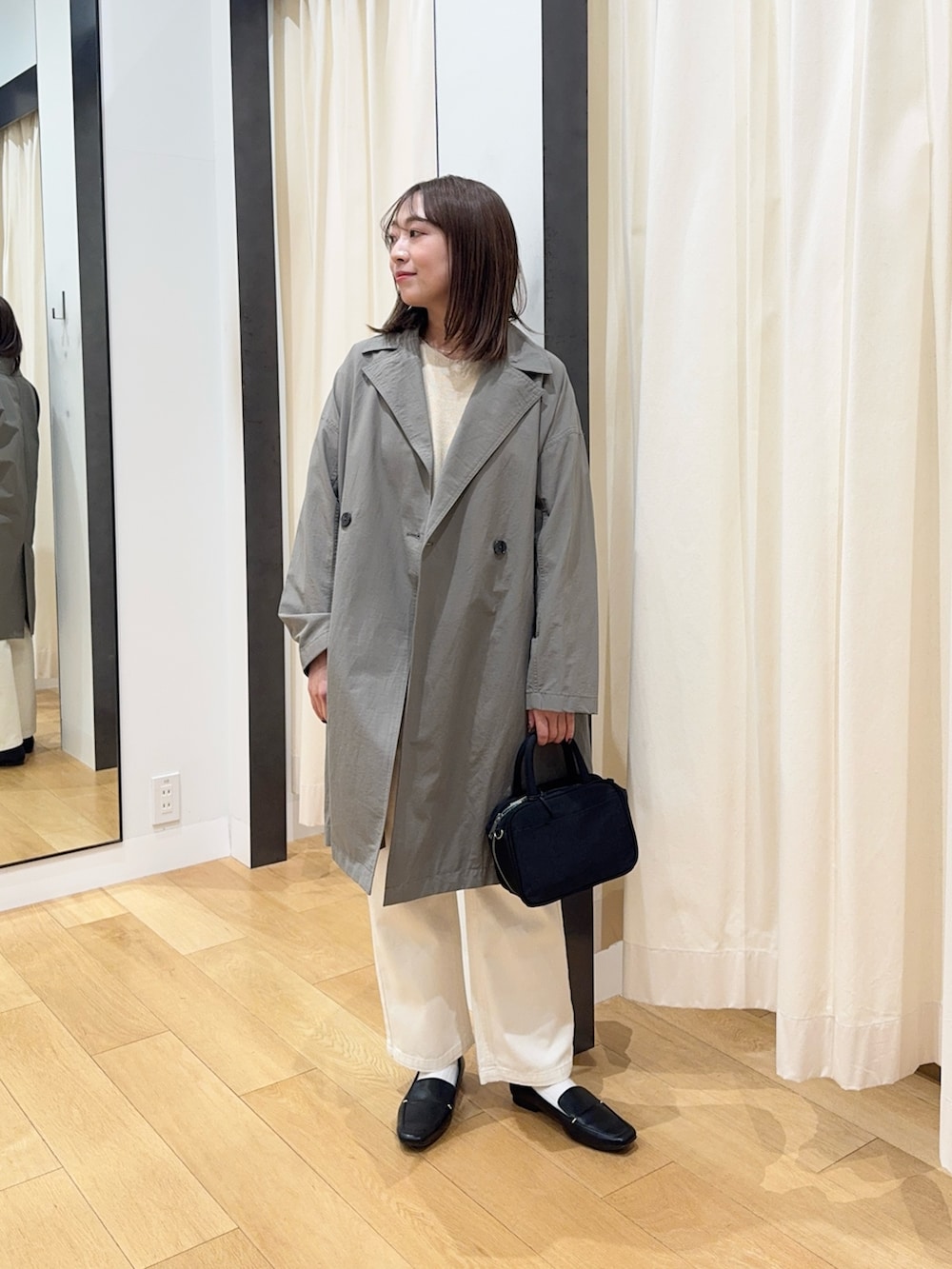 ブラウン系のその他アウター、ホワイト系のニット/セーター、ブラック系のボストンバッグを着用したレディースの冬コーディネートの2枚目の写真