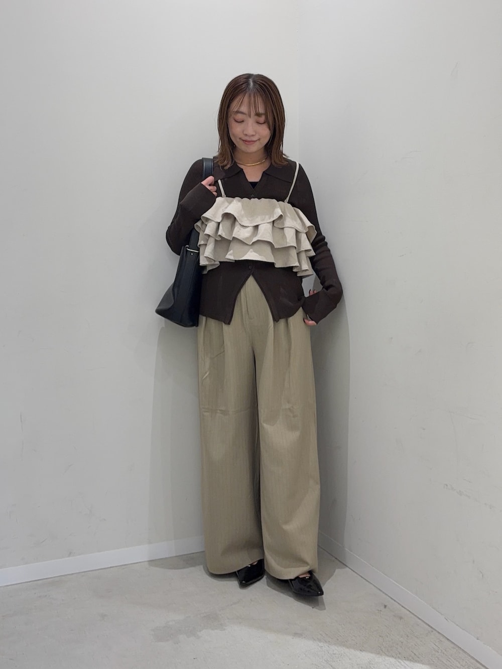 ベージュ系のキャミソール、ブラウン系のカーディガン/ボレロ、ベージュ系のその他パンツを着用したレディースの秋コーディネートの2枚目の写真