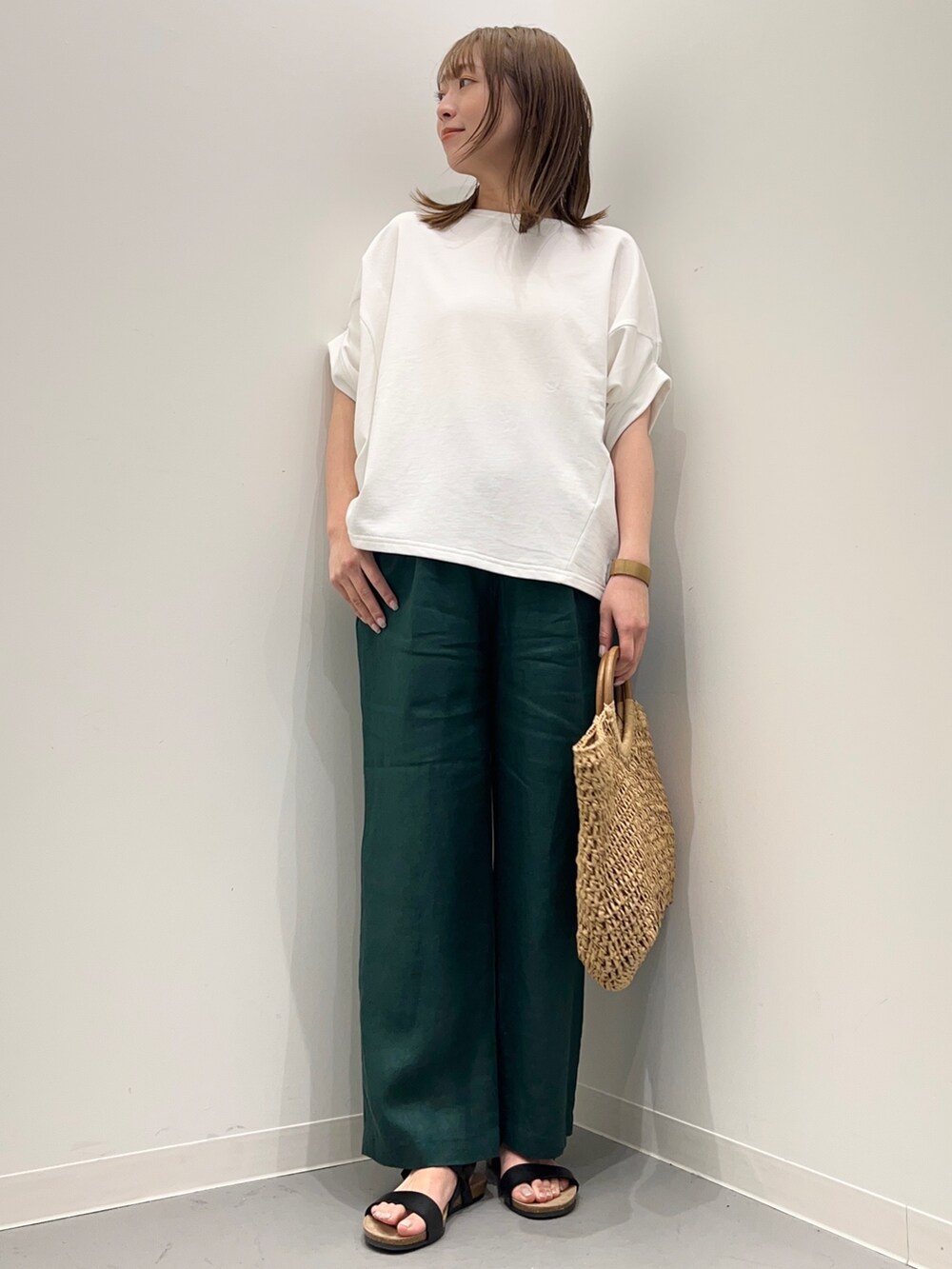 ホワイト系のTシャツ/カットソー、ベージュ系のかごバッグ、グリーン系のその他パンツを着用したレディースの春コーディネートの2枚目の写真