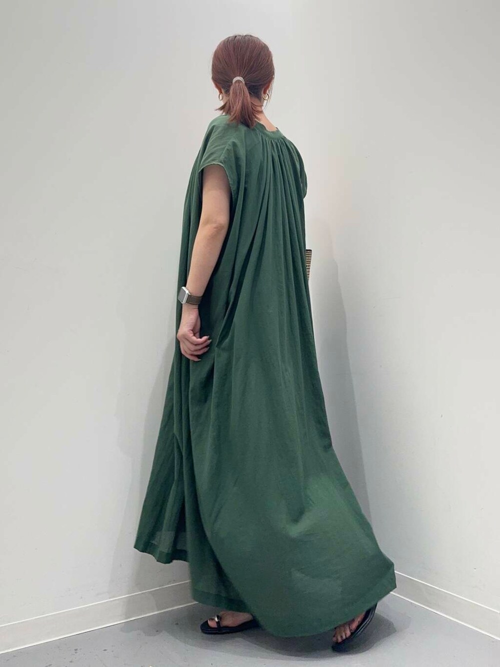 グリーン系のワンピース、ブラック系のサンダルを着用したレディースの夏コーディネートの3枚目の写真