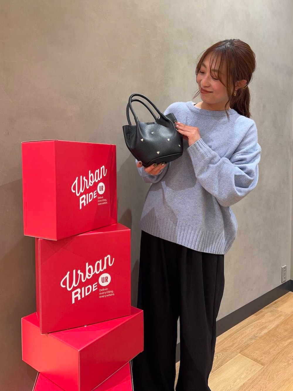 ブルー系のニット/セーター、ブラック系のショルダーバッグを着用したレディースの冬コーディネートの2枚目の写真