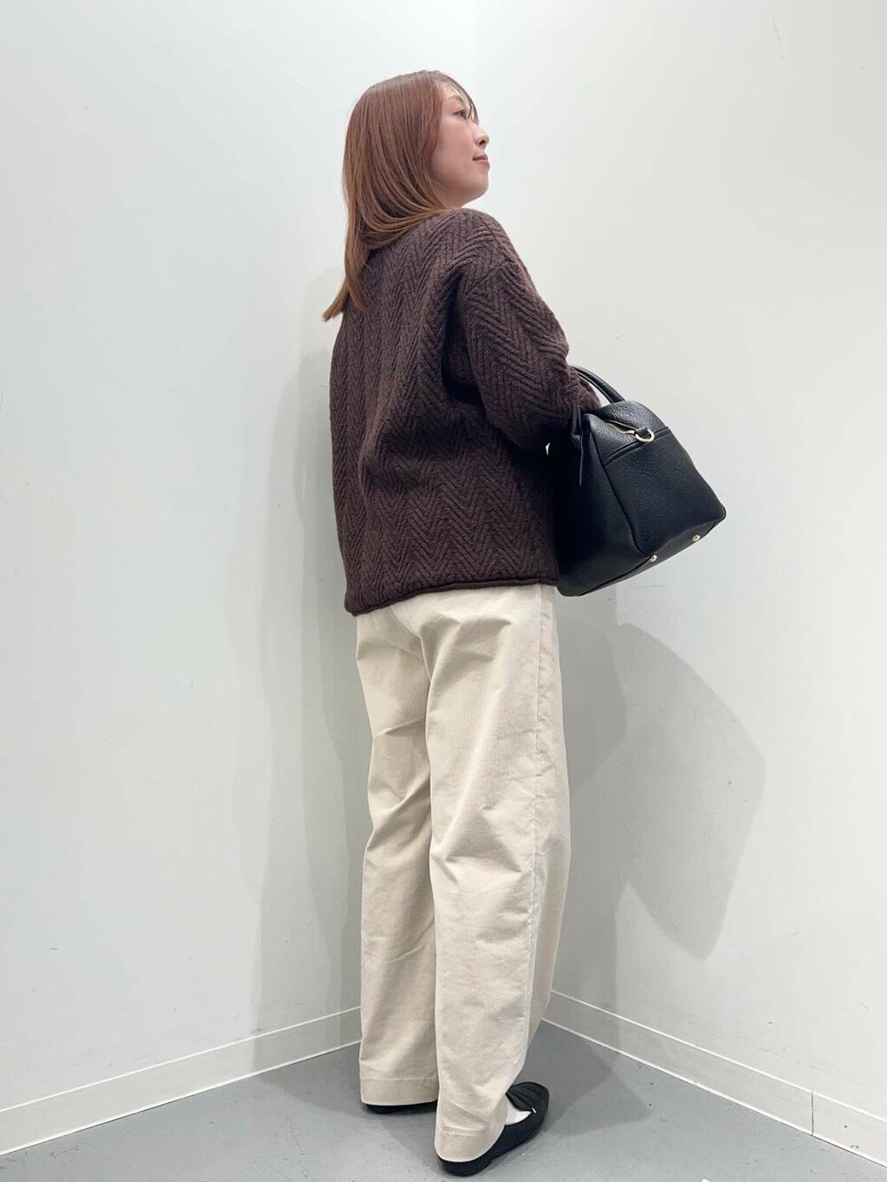 ブラック系のローファー、ブラック系のボストンバッグ、ホワイト系のその他パンツを着用したレディースの冬コーディネートの4枚目の写真