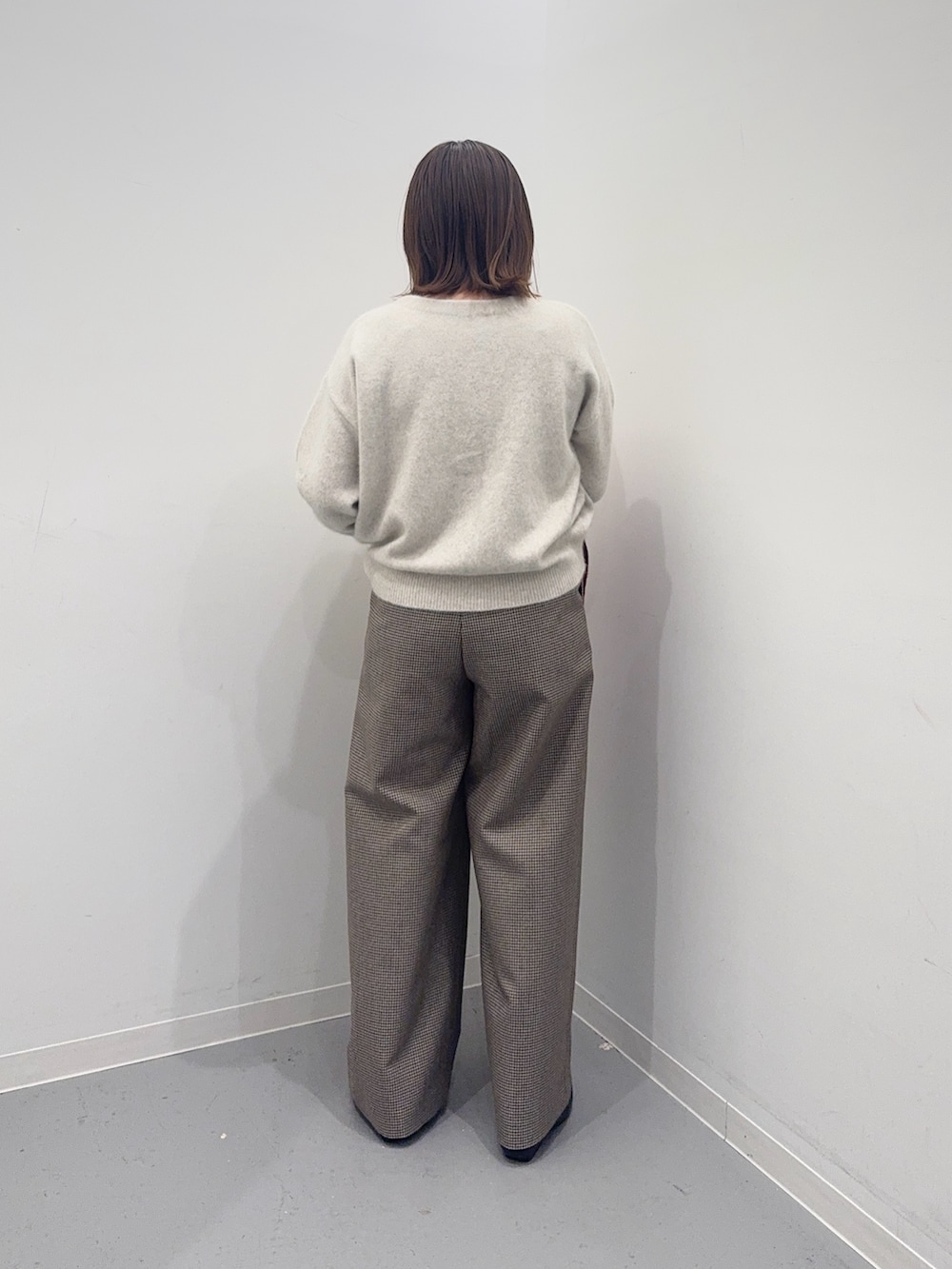 ベージュ系のハンドバッグ、ホワイト系のカーディガン/ボレロ、グリーン系のその他パンツを着用したレディースの冬コーディネートの3枚目の写真