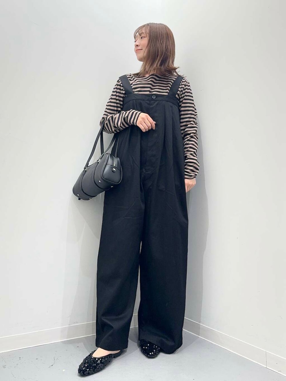 ブラック系のその他シューズ、ブラック系のボストンバッグ、オレンジ系のTシャツ/カットソーを着用したレディースの秋コーディネートの2枚目の写真