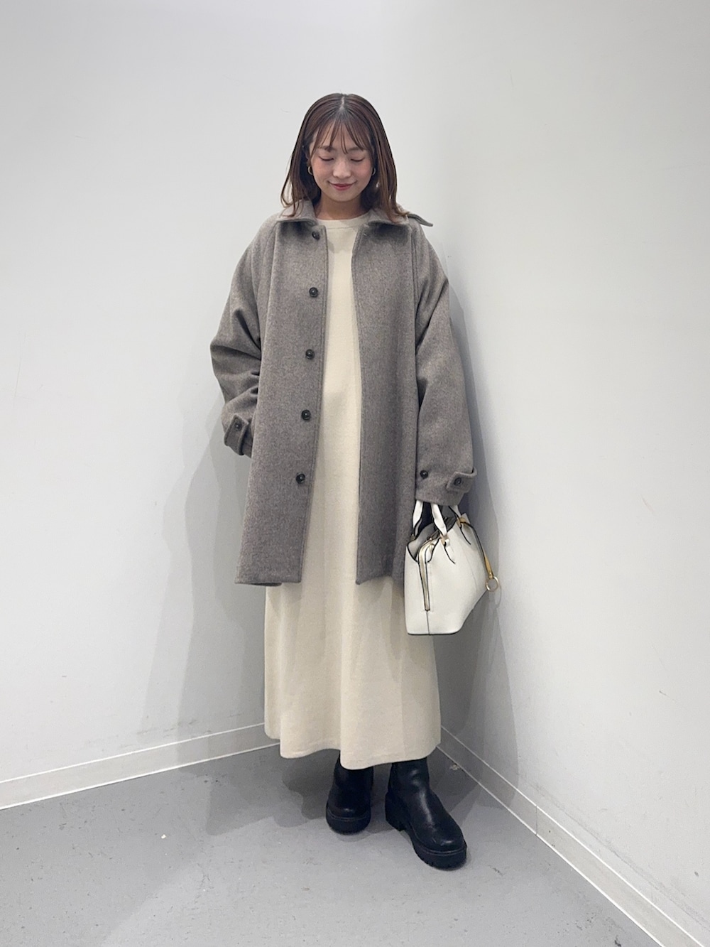 ベージュ系のその他アウター、ベージュ系のワンピース、ホワイト系のハンドバッグを着用したレディースの冬コーディネートの5枚目の写真