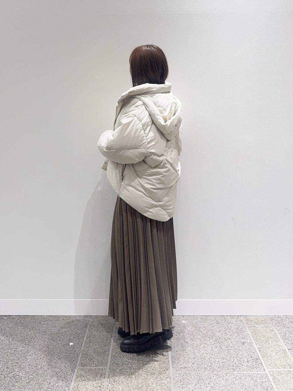 ホワイト系のダウンジャケット/コート、ホワイト系のニット/セーター、ベージュ系のスカートを着用したレディースの冬コーディネートの3枚目の写真