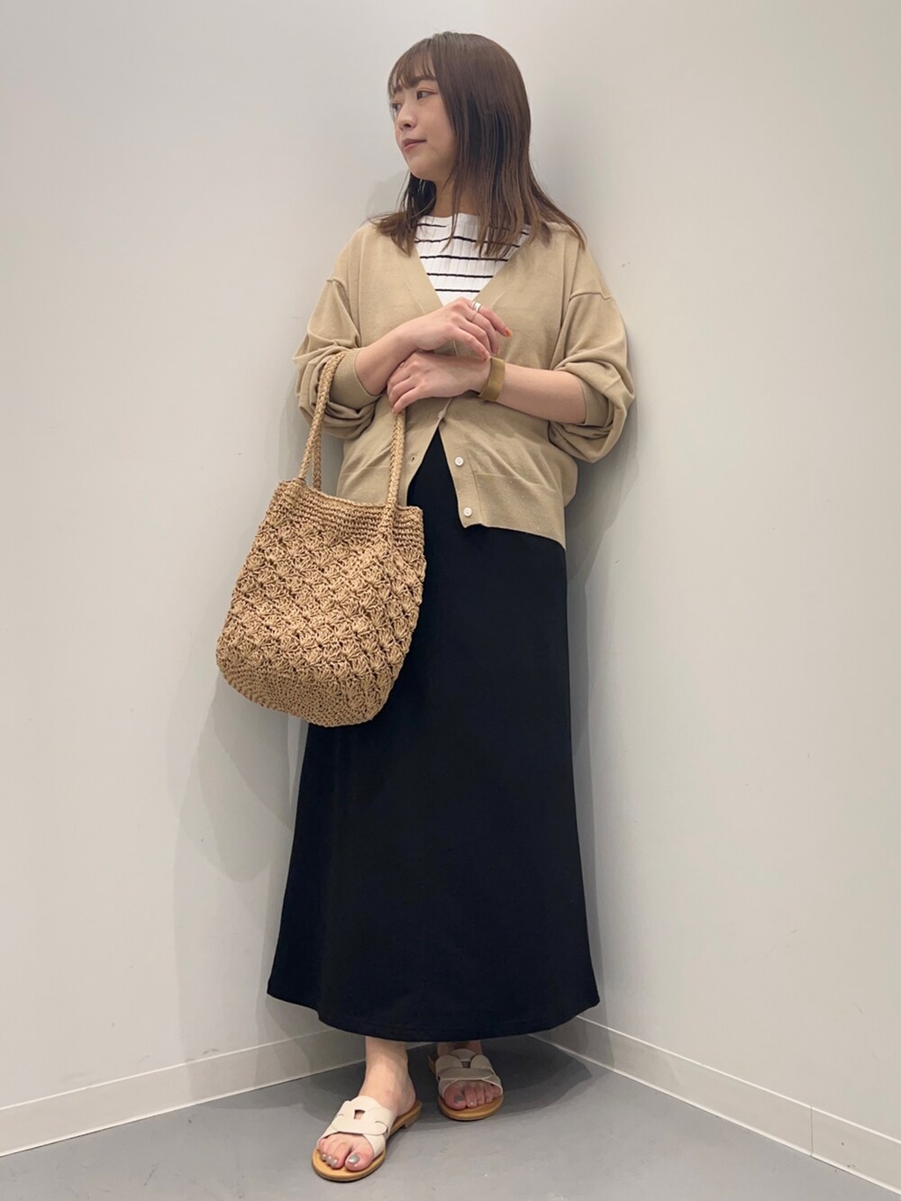 ホワイト系のTシャツ/カットソー、ベージュ系のカーディガン/ボレロ、ブラック系のスカートを着用したレディースの夏コーディネートの5枚目の写真