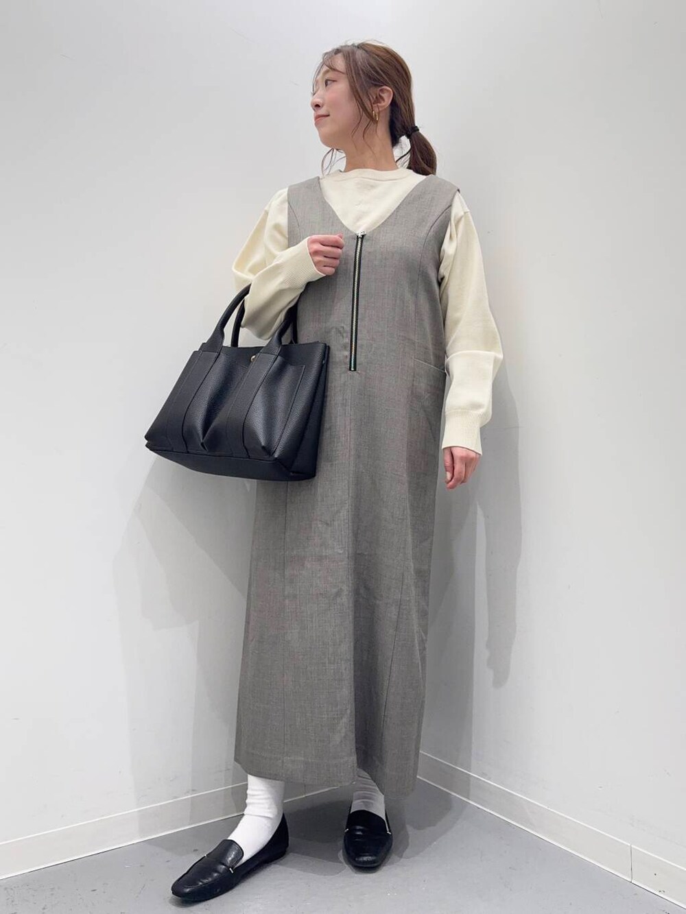 ブラック系のローファー、グレー系のワンピース、ブラック系のトートバッグを着用したレディースの冬コーディネートの2枚目の写真