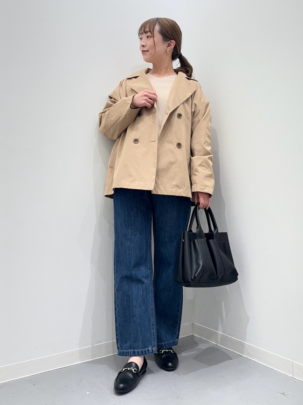 ホワイト系のニット/セーター、ベージュ系のその他アウター、ブルー系のデニムパンツを着用したレディースの春コーディネートの2枚目の写真