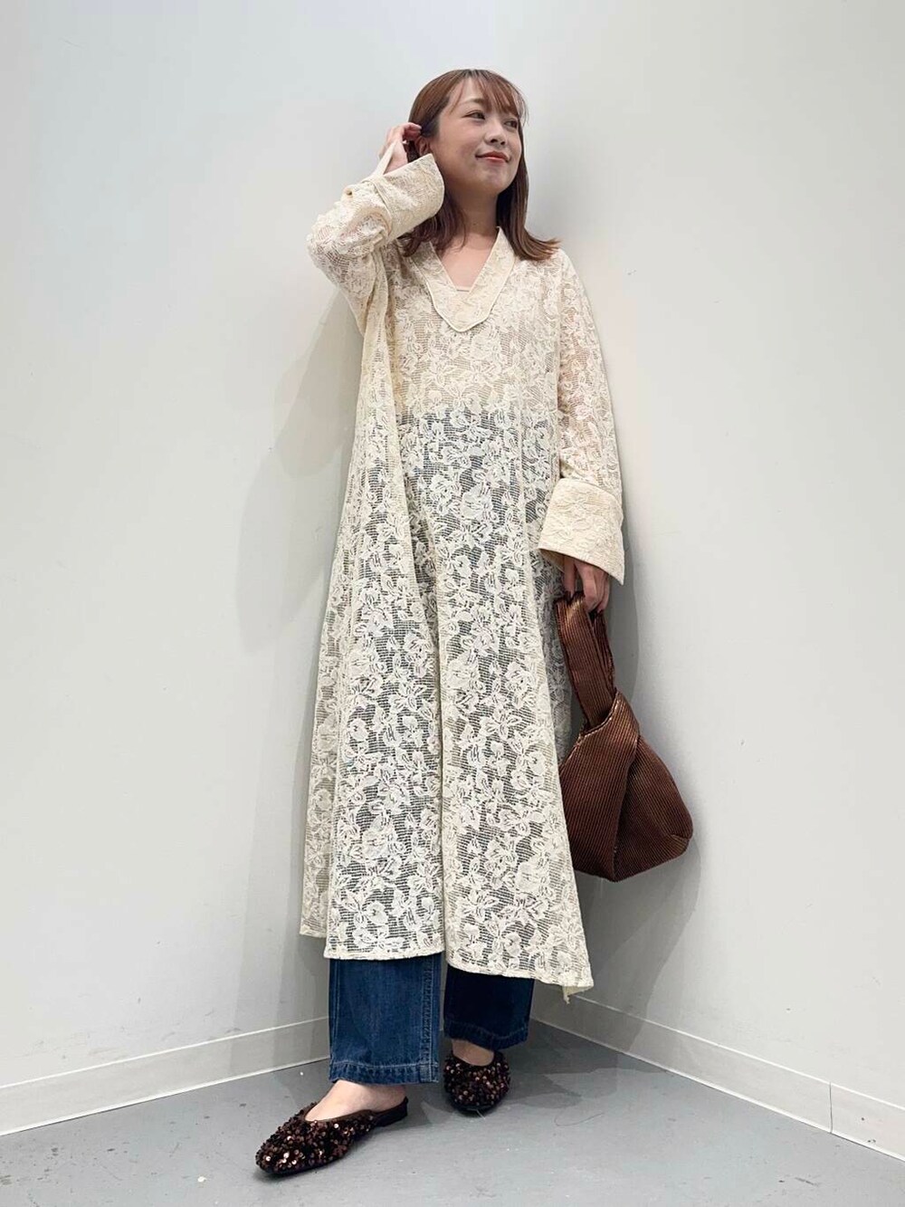 ブラウン系のハンドバッグ、ブルー系のデニムパンツ、ブラウン系のその他シューズを着用したレディースの秋コーディネートの2枚目の写真