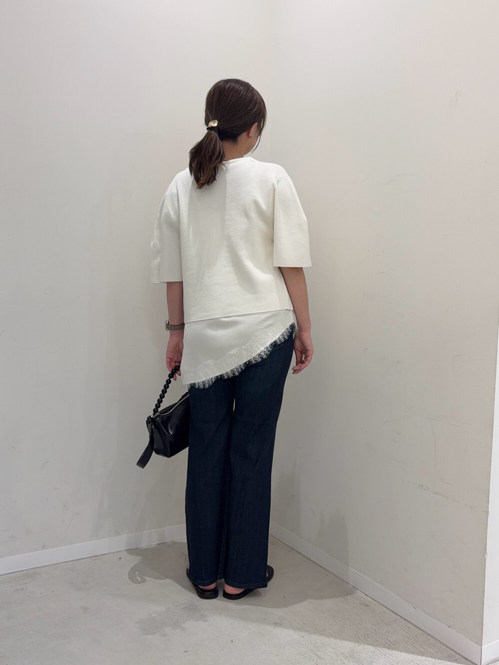 ホワイト系のカーディガン/ボレロ、ホワイト系のキャミソール、ブルー系のデニムパンツを着用したレディースの夏コーディネートの4枚目の写真