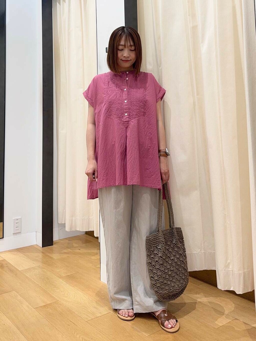 ブラウン系のサンダル、グレー系のトートバッグ、ピンク系のTシャツ/カットソーを着用したレディースの夏コーディネートの5枚目の写真