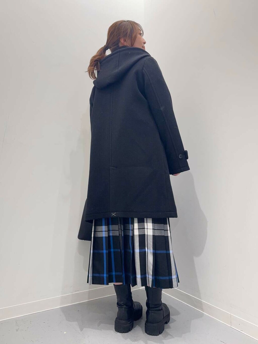 ブラック系のトートバッグ、ブラック系のその他アウター、ブラック系のブーツを着用したレディースの冬コーディネートの8枚目の写真