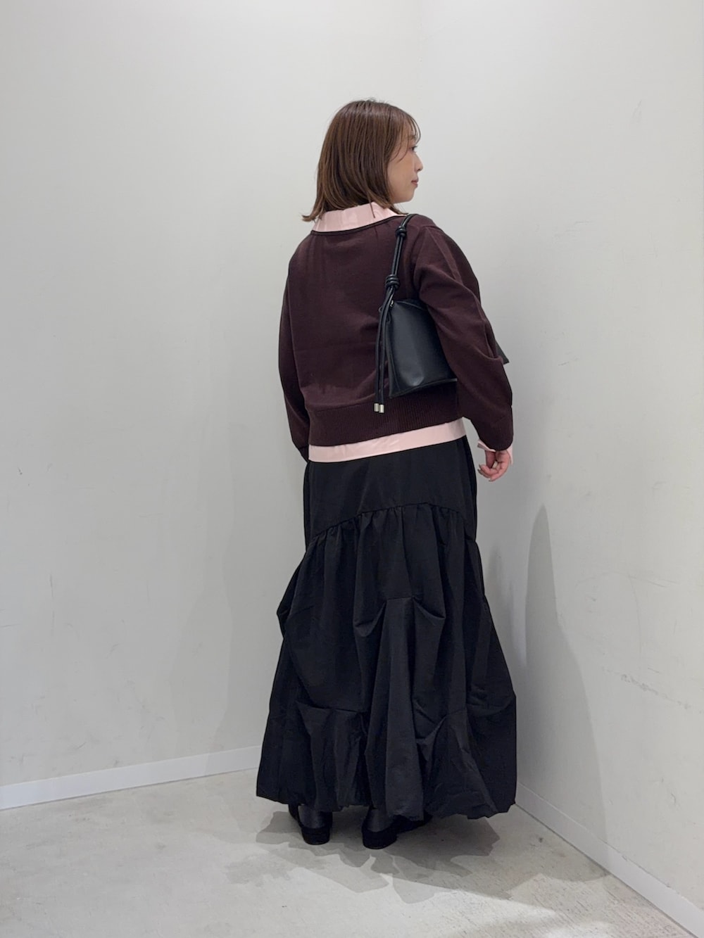 ブラウン系のカーディガン/ボレロ、ブラック系のスカート、ブラック系のパンプスを着用したレディースの秋コーディネートの3枚目の写真