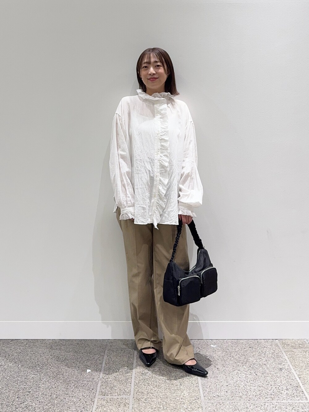 ホワイト系のシャツ/ブラウス、ベージュ系のその他パンツ、ブラック系のショルダーバッグを着用したレディースの秋コーディネートの4枚目の写真