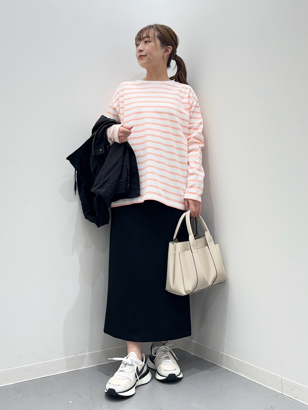ピンク系のTシャツ/カットソー、ブラック系のマウンテンパーカー、ブラック系のスカートを着用したレディースの春コーディネートの6枚目の写真