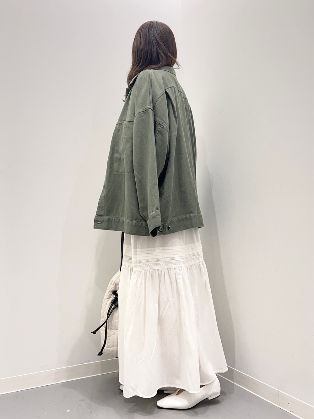 ベージュ系のスウェット、グリーン系のジャケット/アウター、ホワイト系のスカートを着用したレディースの夏コーディネートの3枚目の写真