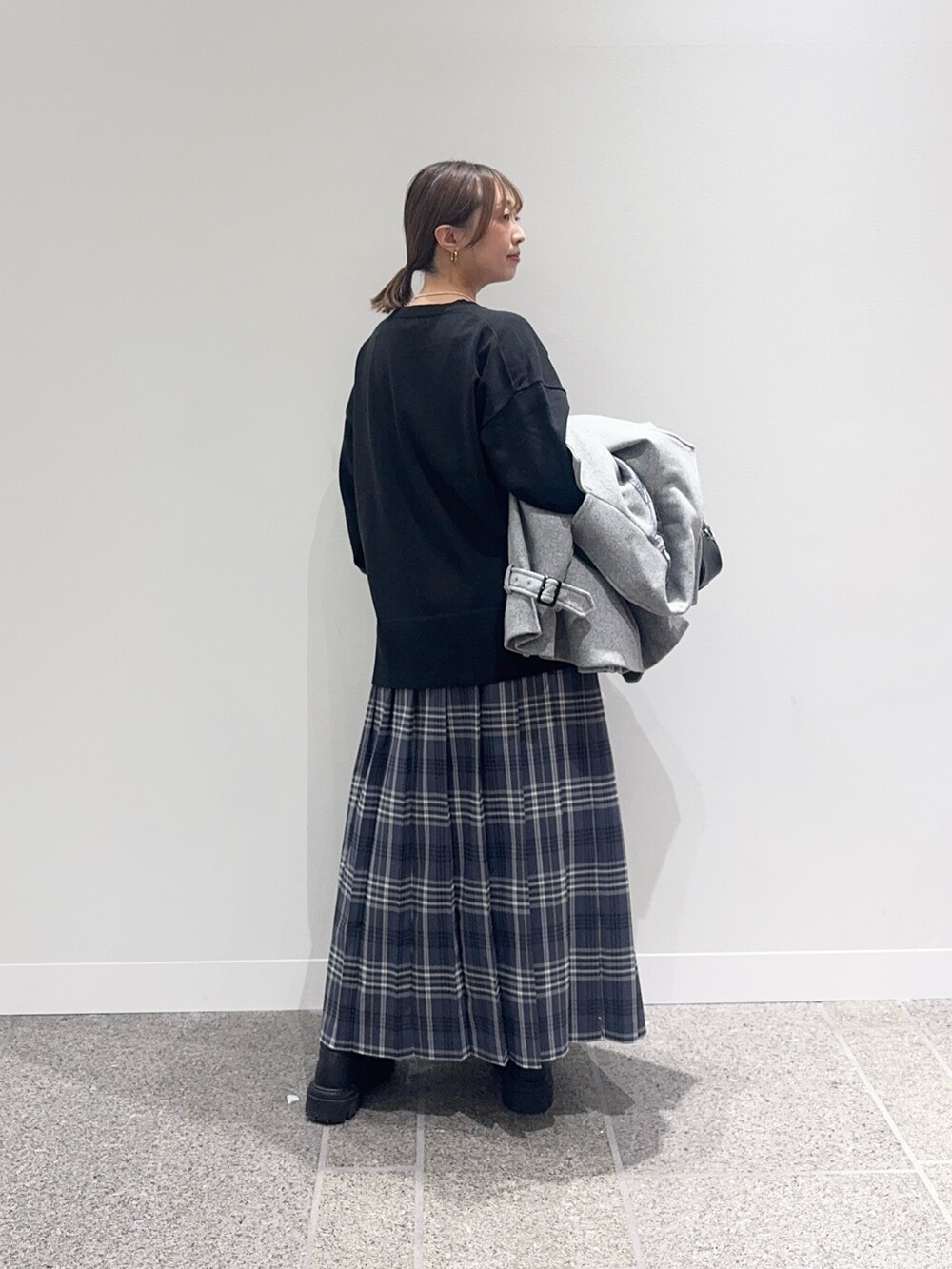 グレー系のその他アウター、ブラック系のニット/セーター、グレー系のスカートを着用したレディースの秋コーディネートの6枚目の写真