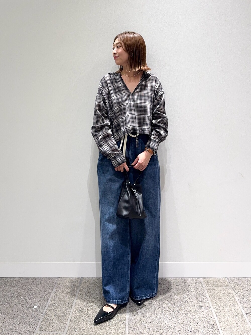 ブラック系のシャツ/ブラウス、ブルー系のデニムパンツ、ブラック系のパンプスを着用したレディースの秋コーディネートの2枚目の写真