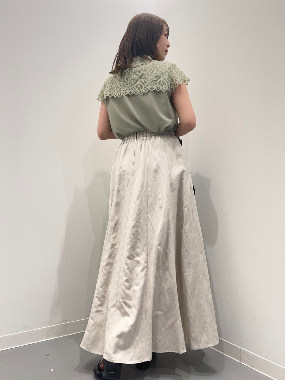 ホワイト系のスカート、グリーン系のシャツ/ブラウス、ブラック系のパンプスを着用したレディースの春コーディネートの5枚目の写真