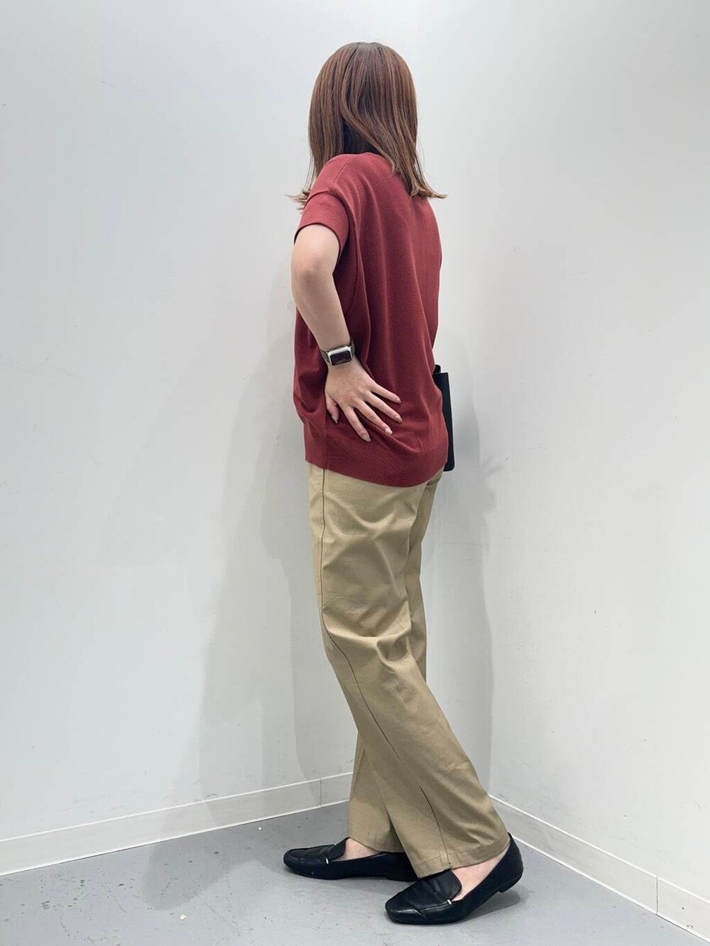 ブラック系のローファー、ブラック系のトートバッグ、レッド系のニット/セーターを着用したレディースの夏コーディネートの2枚目の写真