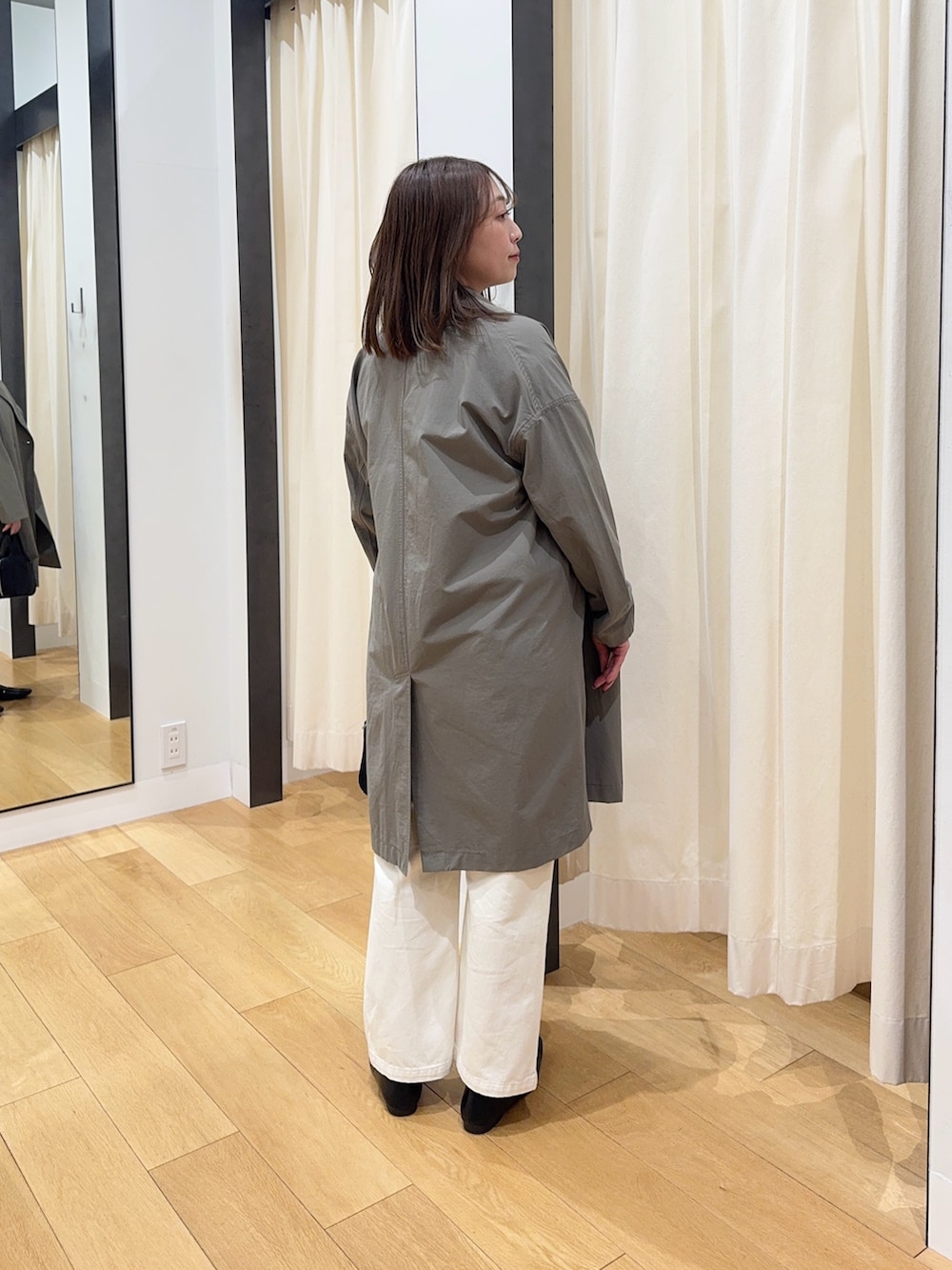 ブラウン系のその他アウター、ホワイト系のニット/セーター、ブラック系のボストンバッグを着用したレディースの冬コーディネートの3枚目の写真