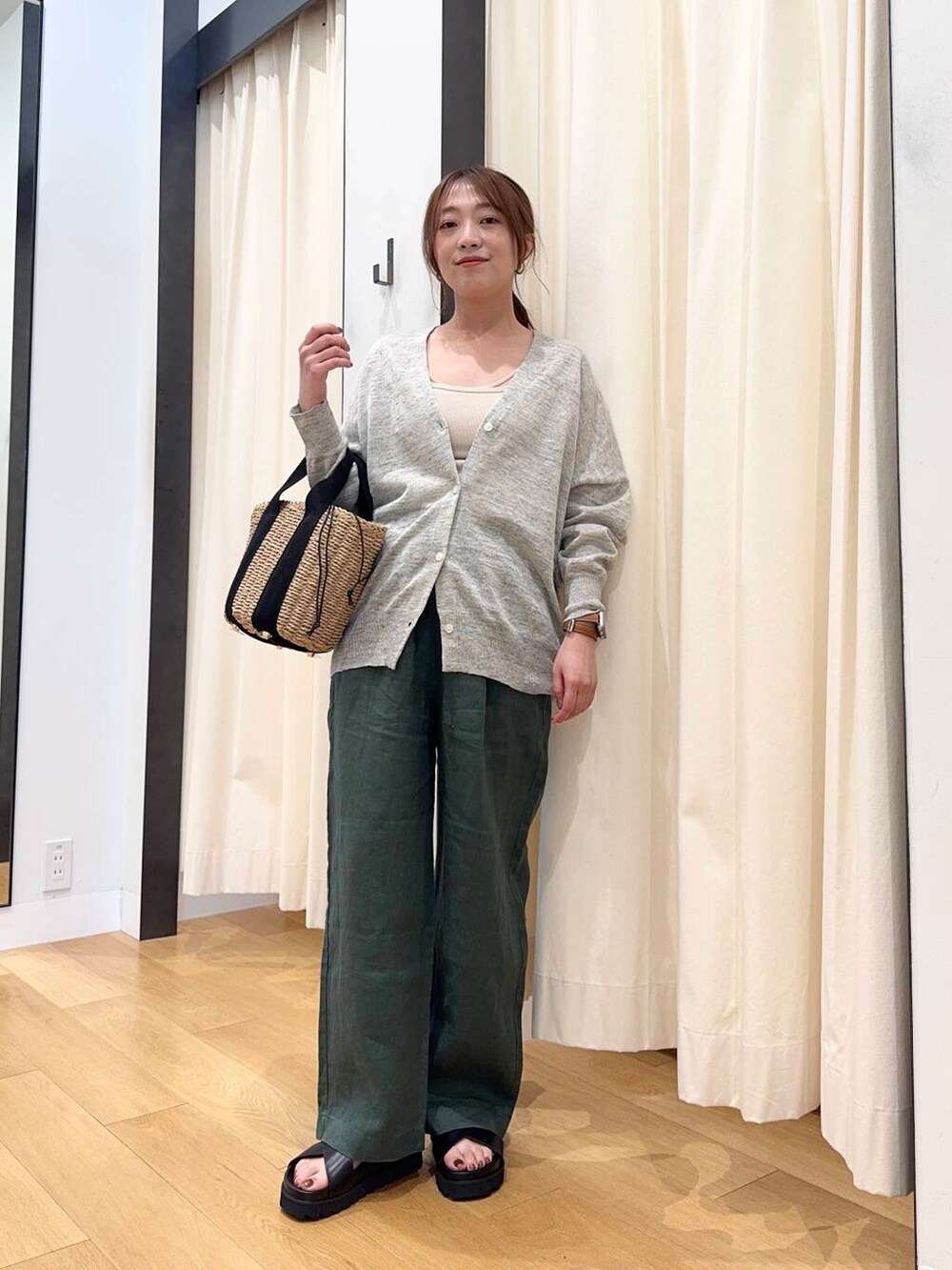 グレー系のカーディガン/ボレロ、ベージュ系のハンドバッグ、グリーン系のその他パンツを着用したレディースの春コーディネートの2枚目の写真