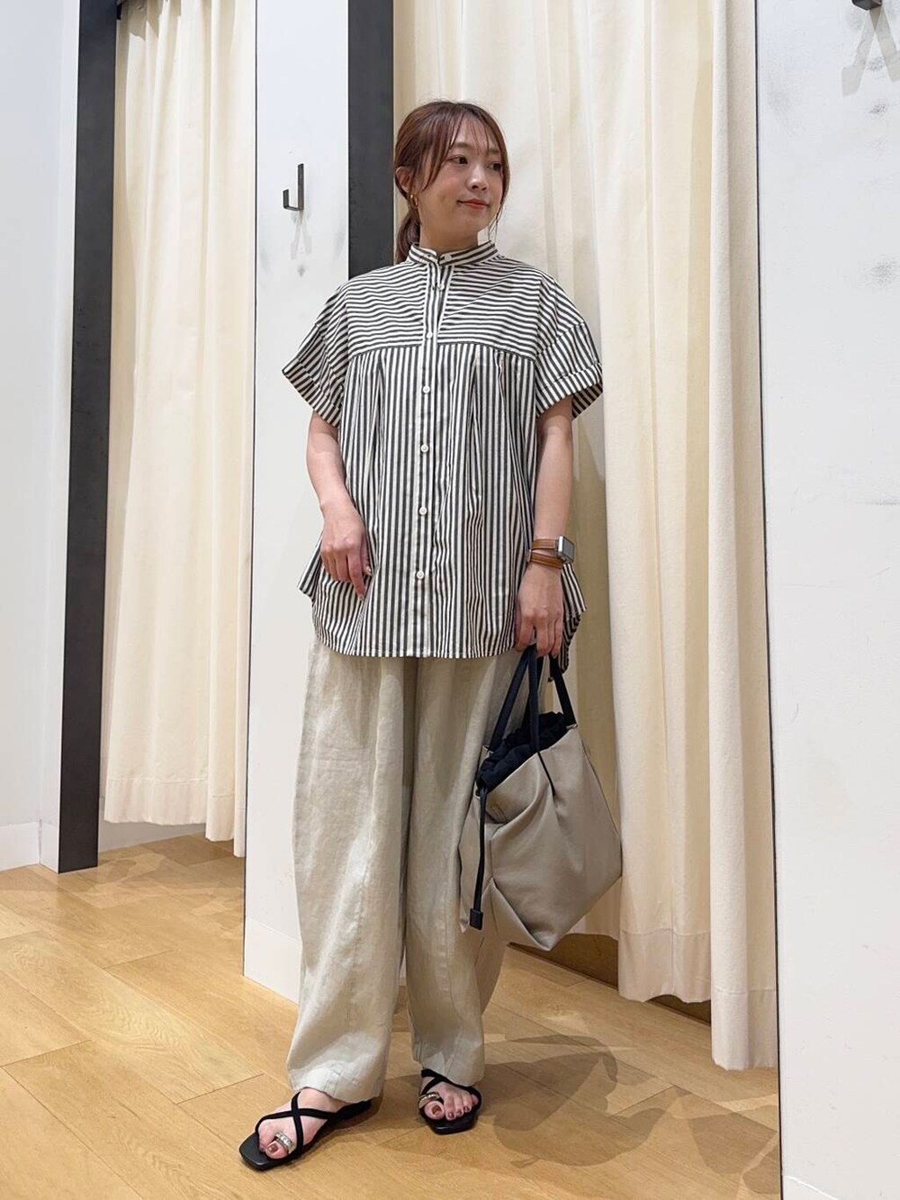 ベージュ系のショルダーバッグ、ブラック系のシャツ/ブラウス、ブラック系のサンダルを着用したレディースの夏コーディネートの2枚目の写真