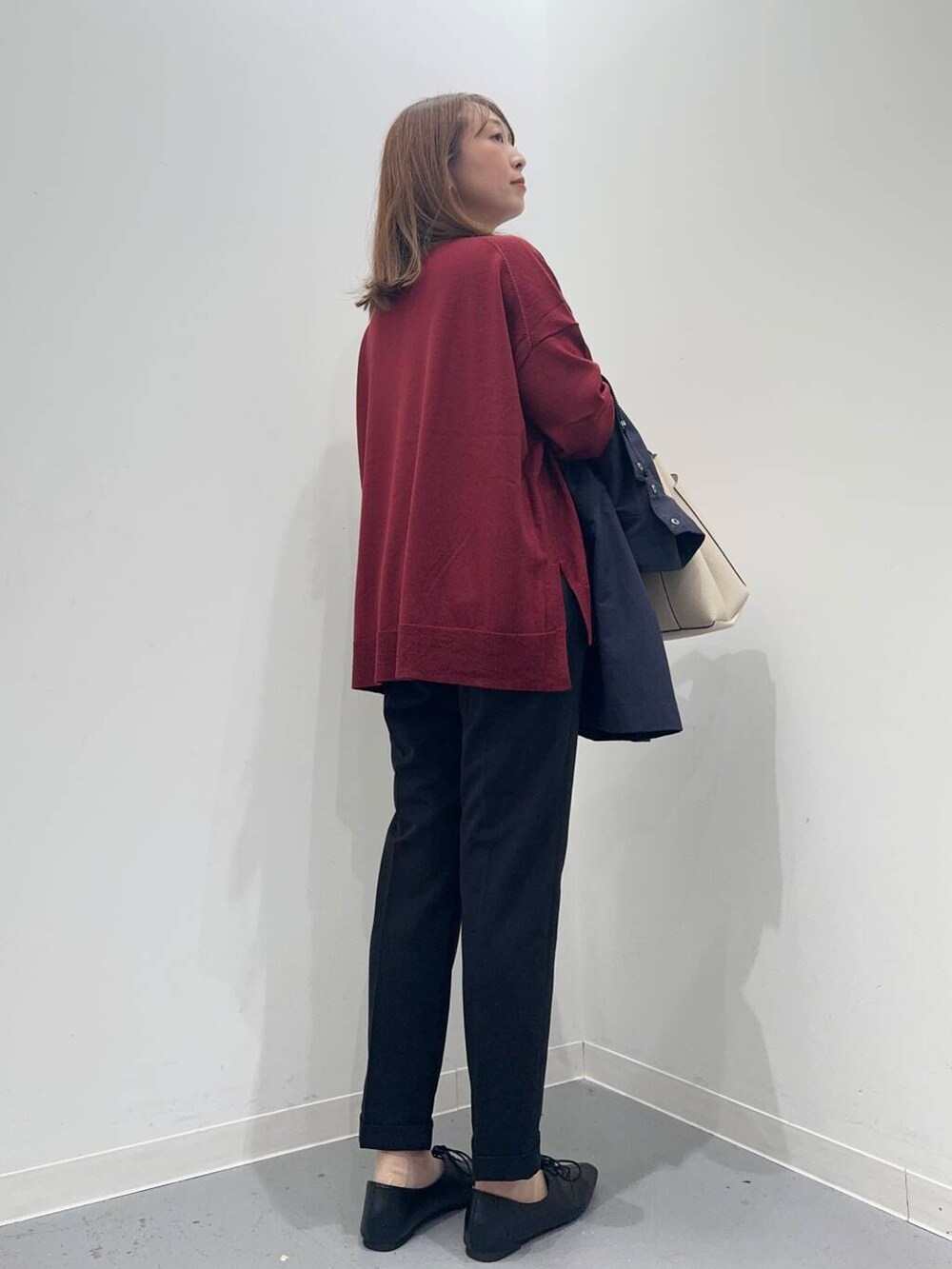 ブラック系のトートバッグ、レッド系のニット/セーター、ブラック系のその他パンツを着用したレディースの秋コーディネートの7枚目の写真
