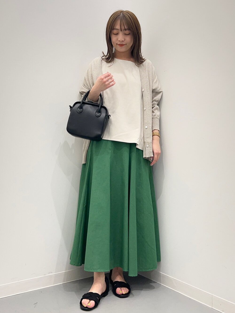 グレー系のTシャツ/カットソー、ブラック系のサンダル、グリーン系のスカートを着用したレディースの春コーディネートの9枚目の写真