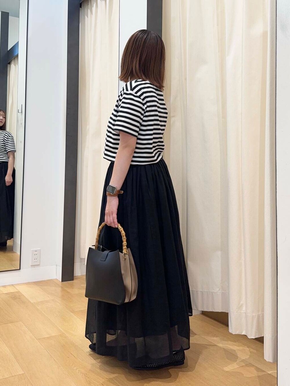 ブラック系のバレエシューズ、ブラック系のワンピース、ブラック系のハンドバッグを着用したレディースの夏コーディネートの4枚目の写真