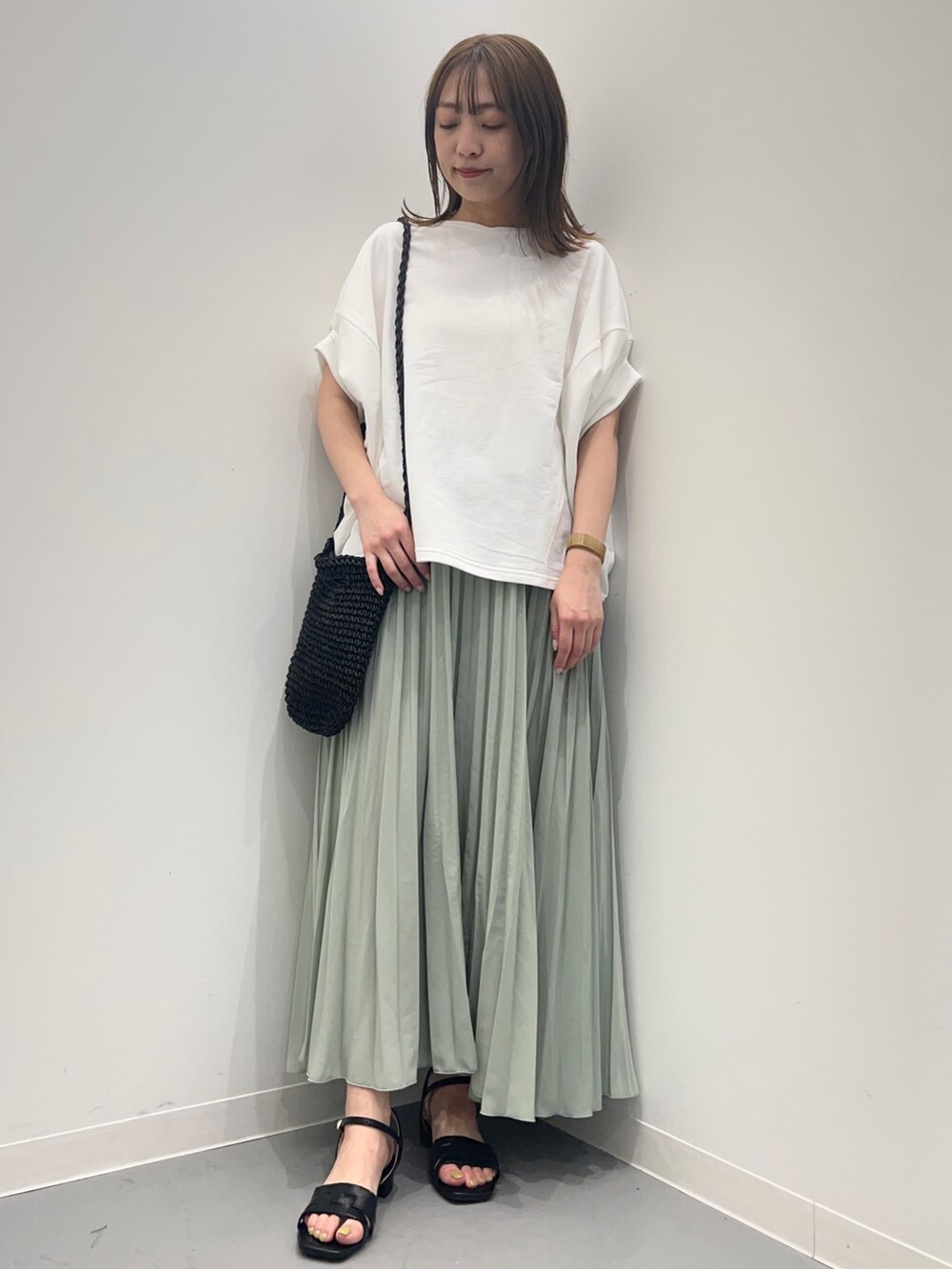 ホワイト系のTシャツ/カットソー、グリーン系のスカートを着用したレディースの春コーディネートの2枚目の写真