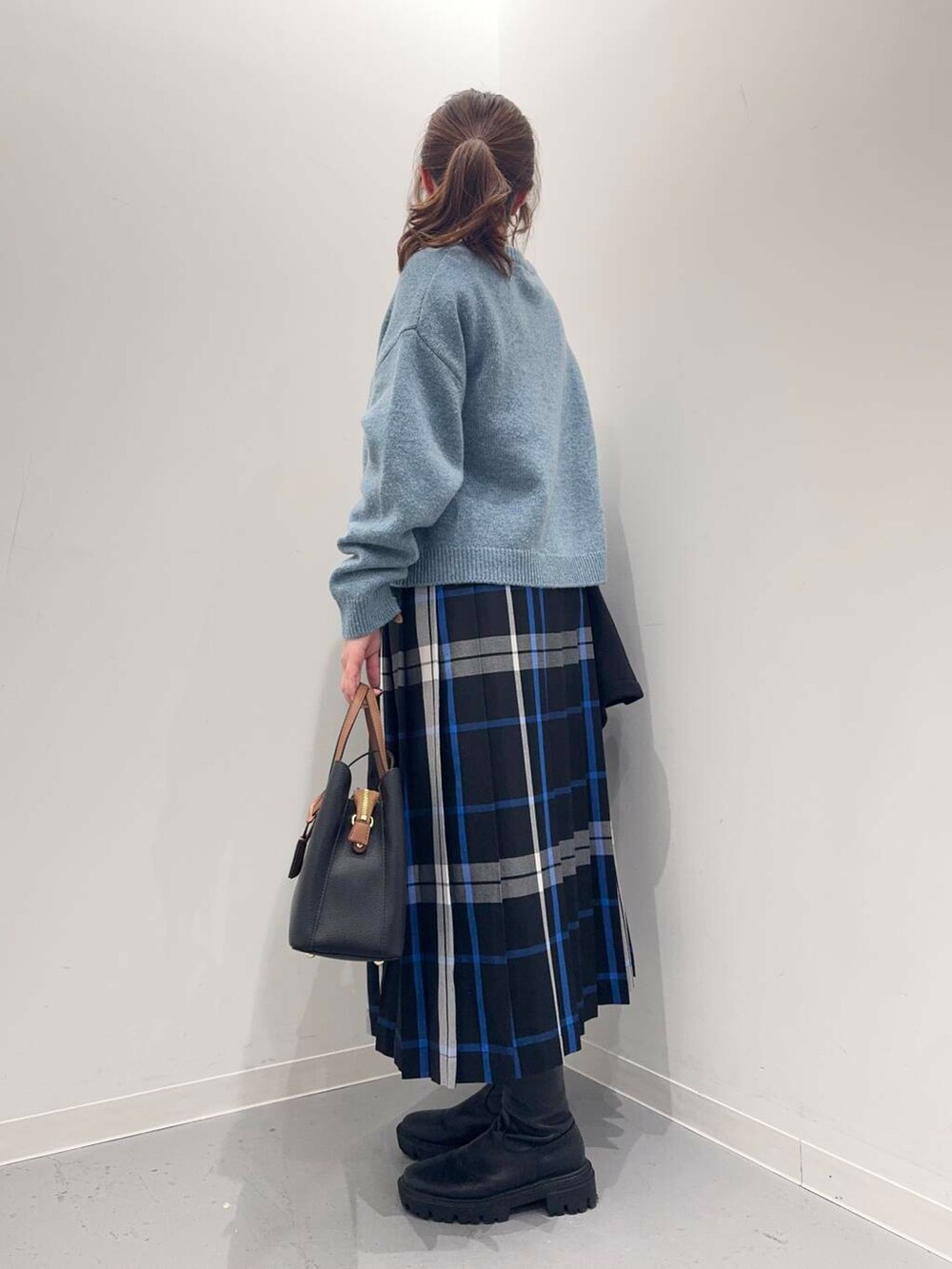 ブラック系のトートバッグ、ブラック系のその他アウター、ブラック系のブーツを着用したレディースの冬コーディネートの2枚目の写真