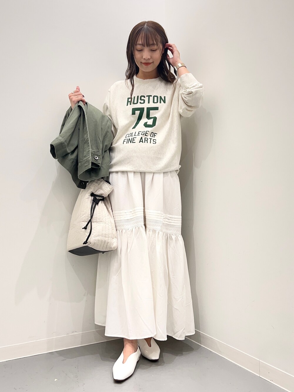 ベージュ系のスウェット、グリーン系のジャケット/アウター、ホワイト系のスカートを着用したレディースの夏コーディネートの6枚目の写真