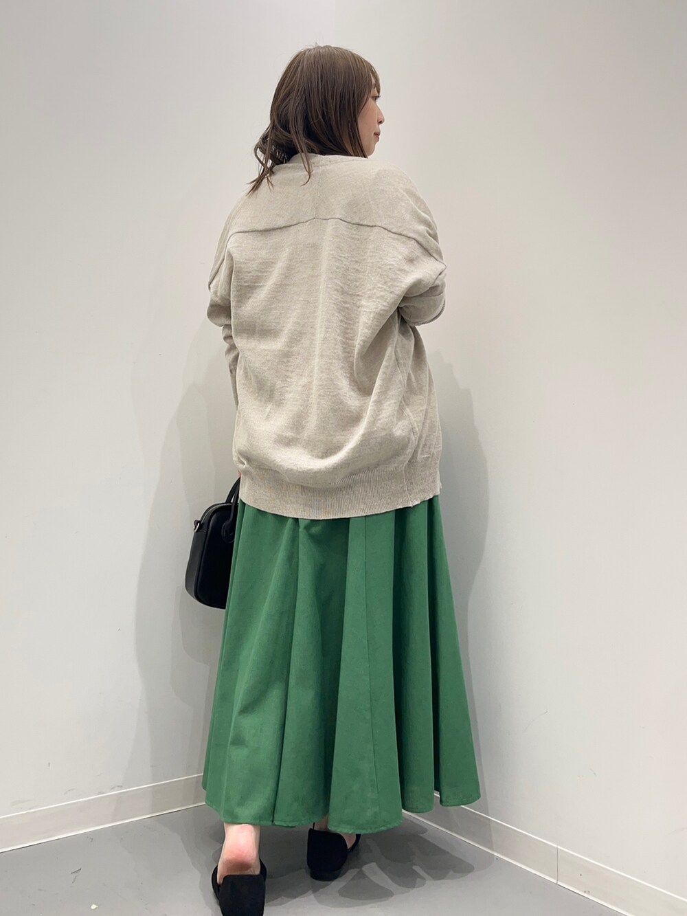 グレー系のTシャツ/カットソー、ブラック系のサンダル、グリーン系のスカートを着用したレディースの春コーディネートの8枚目の写真