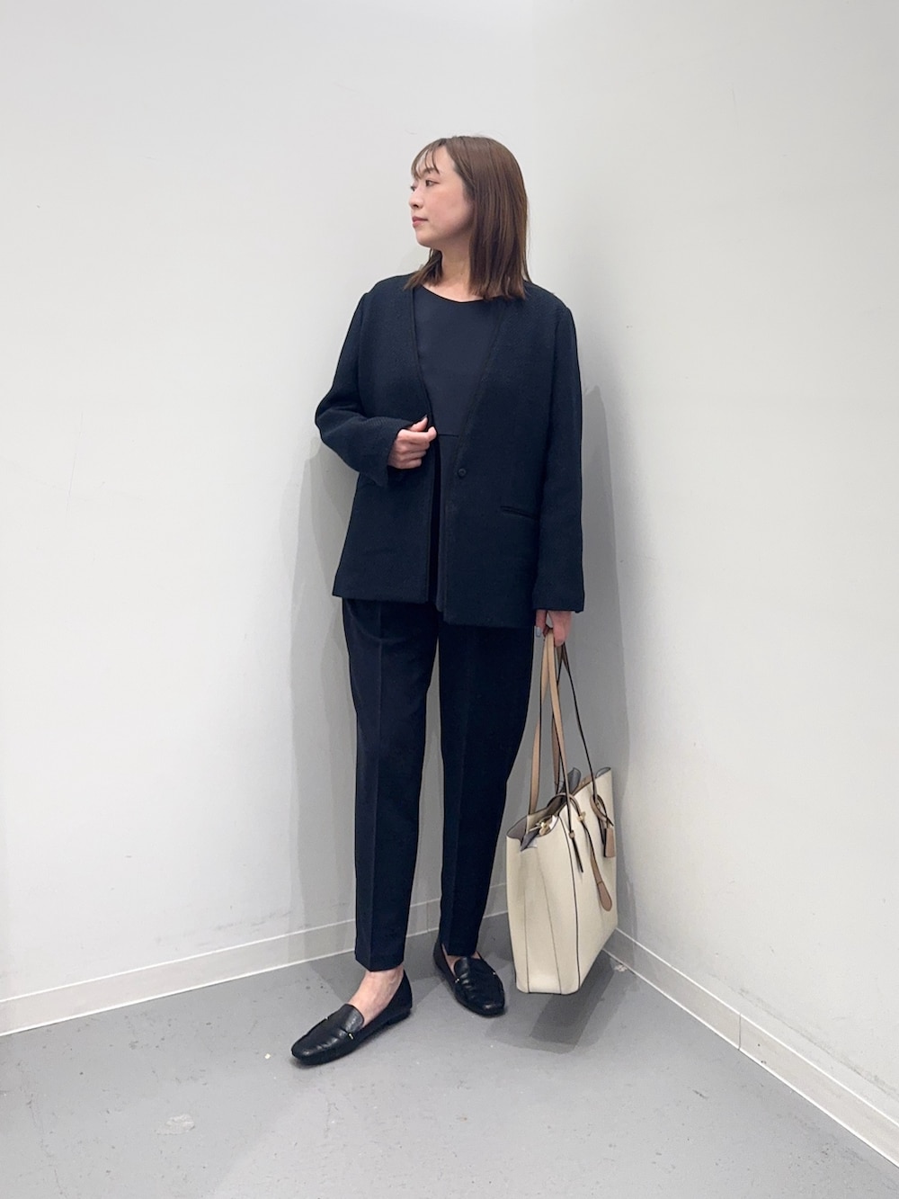 ブルー系のセットアップ、ブルー系のスーツジャケット、ホワイト系のトートバッグを着用したレディースの冬コーディネートの4枚目の写真