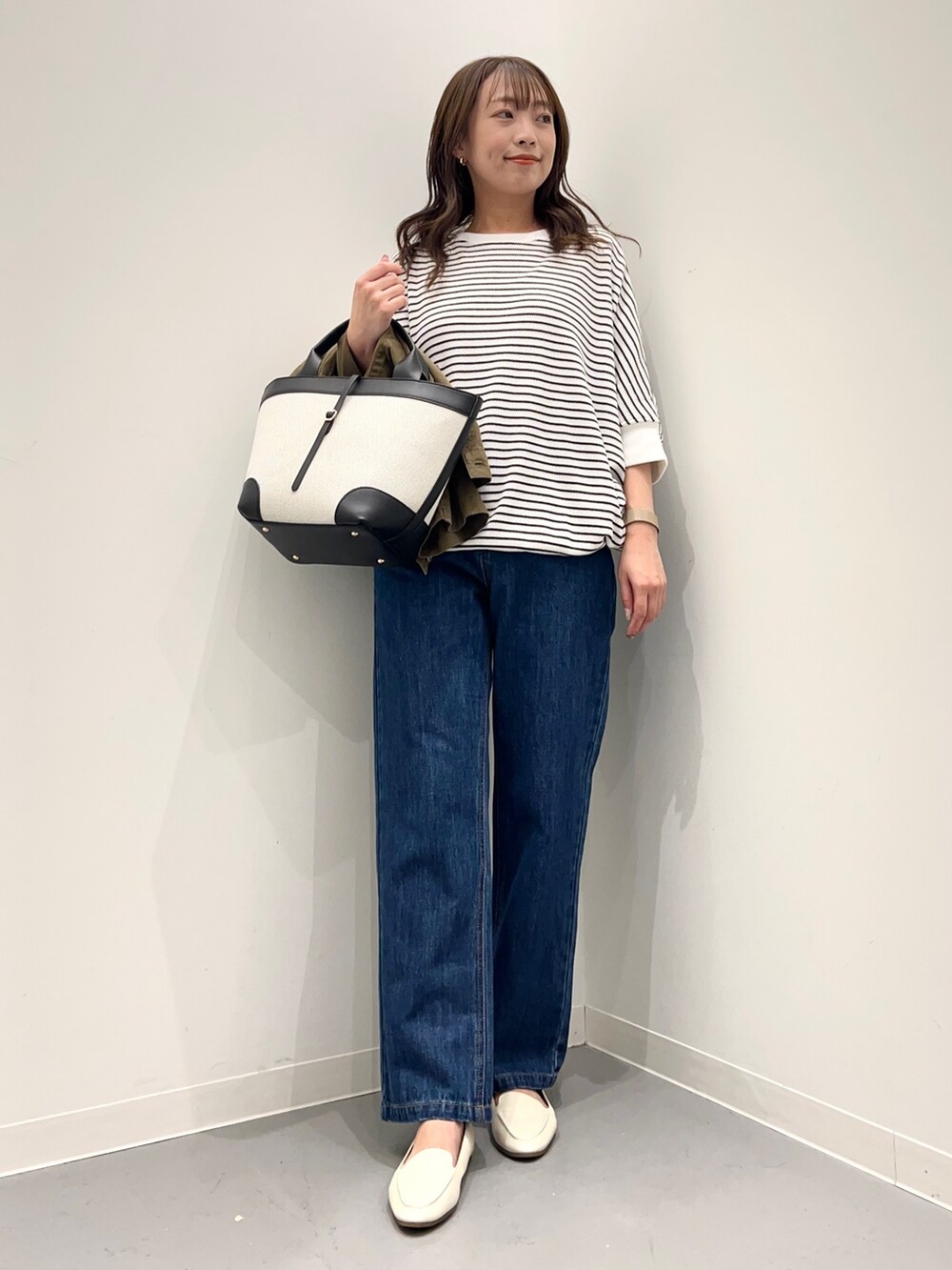 ブルー系のデニムパンツ、グリーン系のその他アウター、ホワイト系のTシャツ/カットソーを着用したレディースの秋コーディネートの7枚目の写真