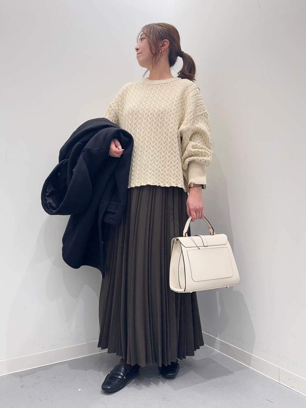 ブラック系のローファー、ブラック系のその他アウター、ホワイト系のハンドバッグを着用したレディースの冬コーディネートの4枚目の写真