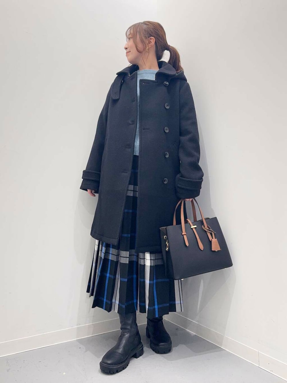 ブラック系のトートバッグ、ブラック系のその他アウター、ブラック系のブーツを着用したレディースの冬コーディネートの6枚目の写真