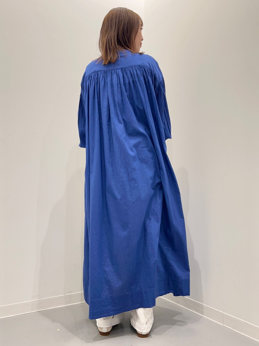 ブルー系のワンピース、ホワイト系のその他パンツ、ブラック系のショルダーバッグを着用したレディースの春コーディネートの6枚目の写真