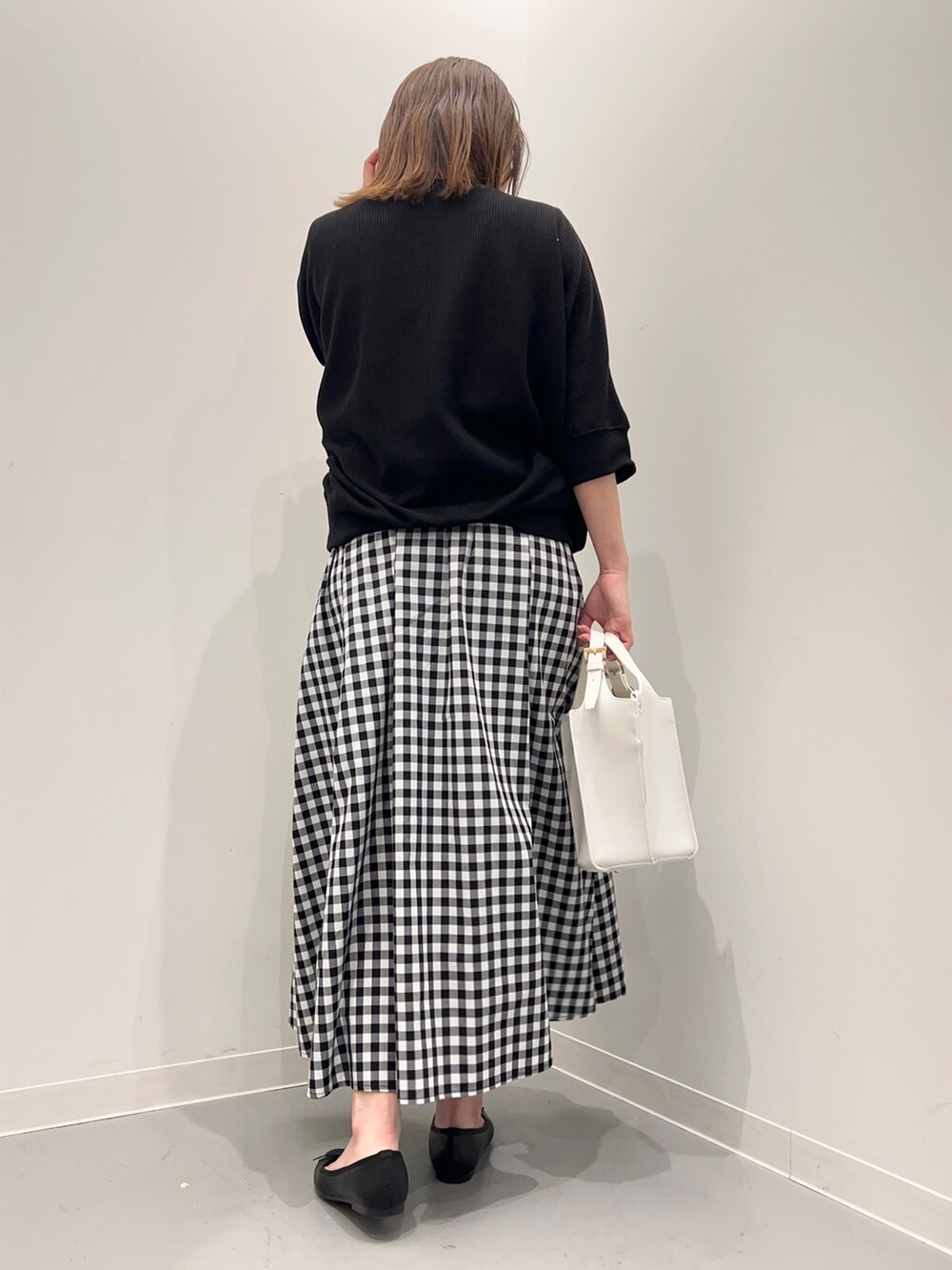 ブラック系のTシャツ/カットソー、その他のスカート、ホワイト系のトートバッグを着用したレディースの春コーディネートの4枚目の写真