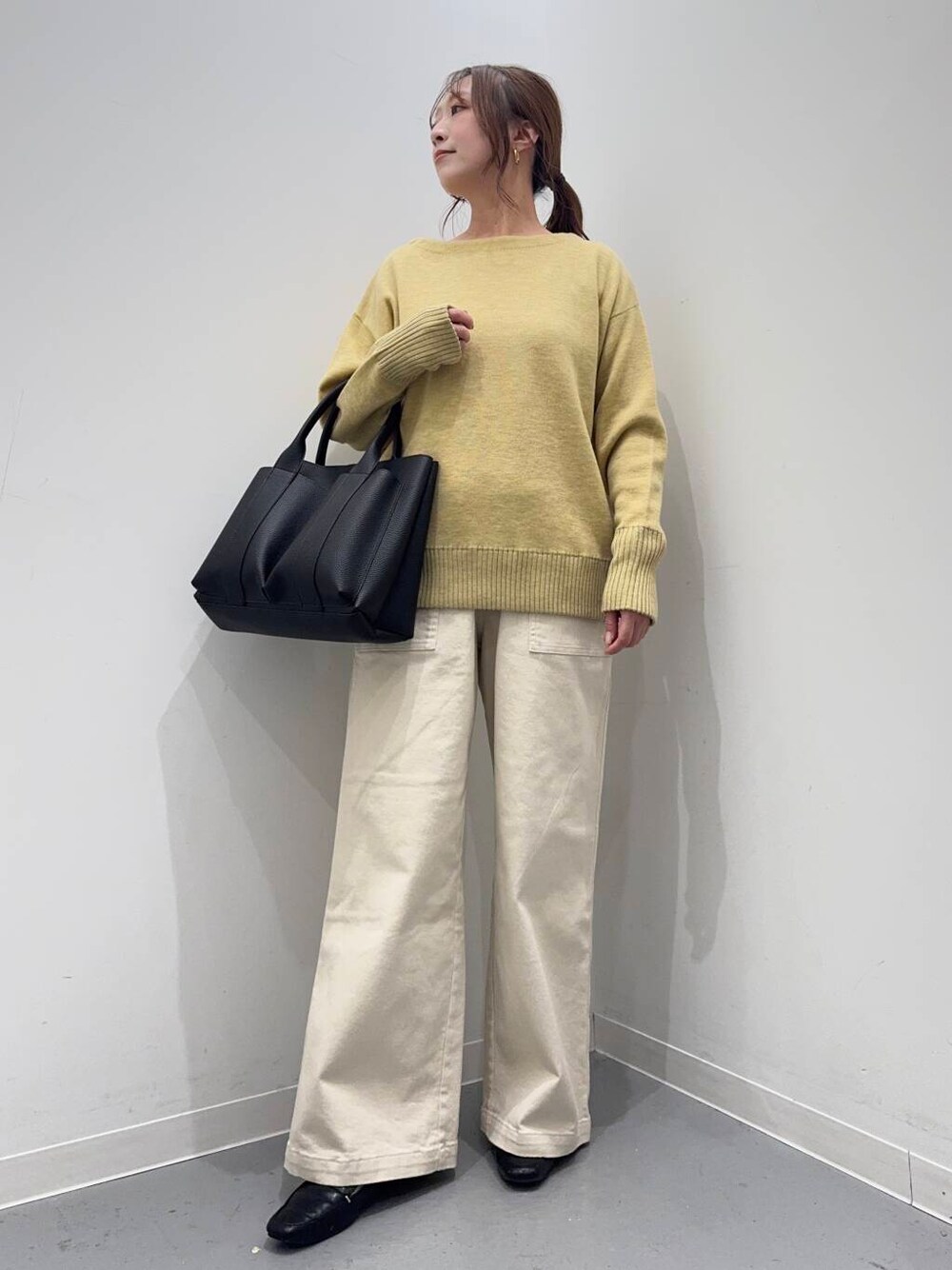 ブラック系のローファー、ブラック系のトートバッグ、イエロー系のニット/セーターを着用したレディースの冬コーディネートの4枚目の写真